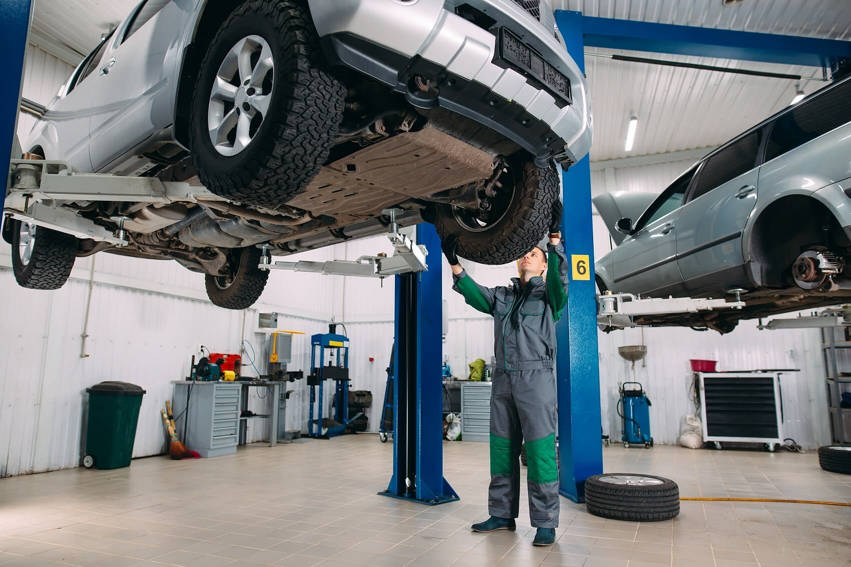 mechanic working on car loaded on lift